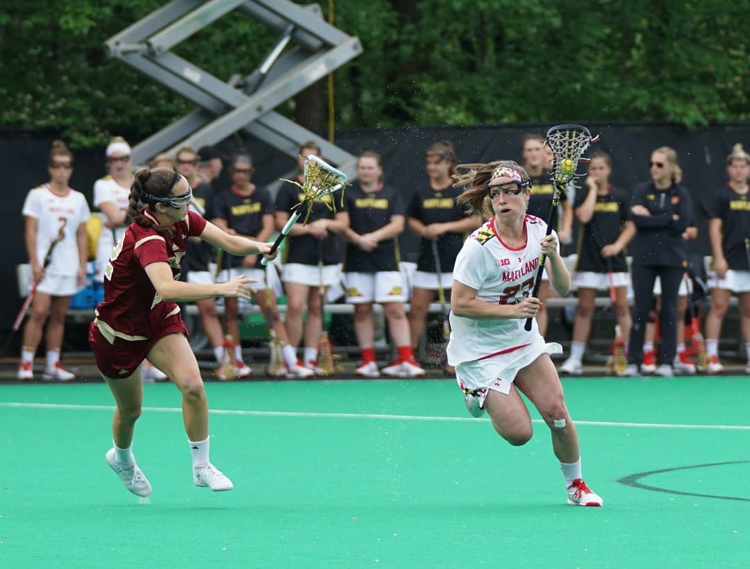 women playing lacrosse game during daytime